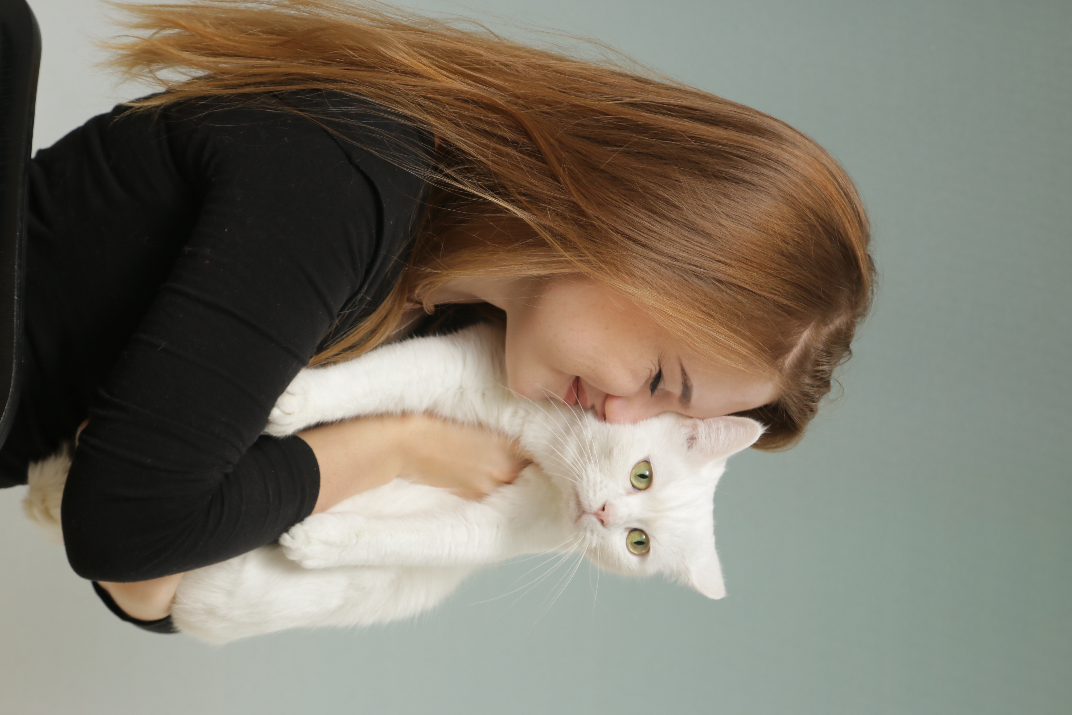 Frau mit weißer Katze auf dem Arm