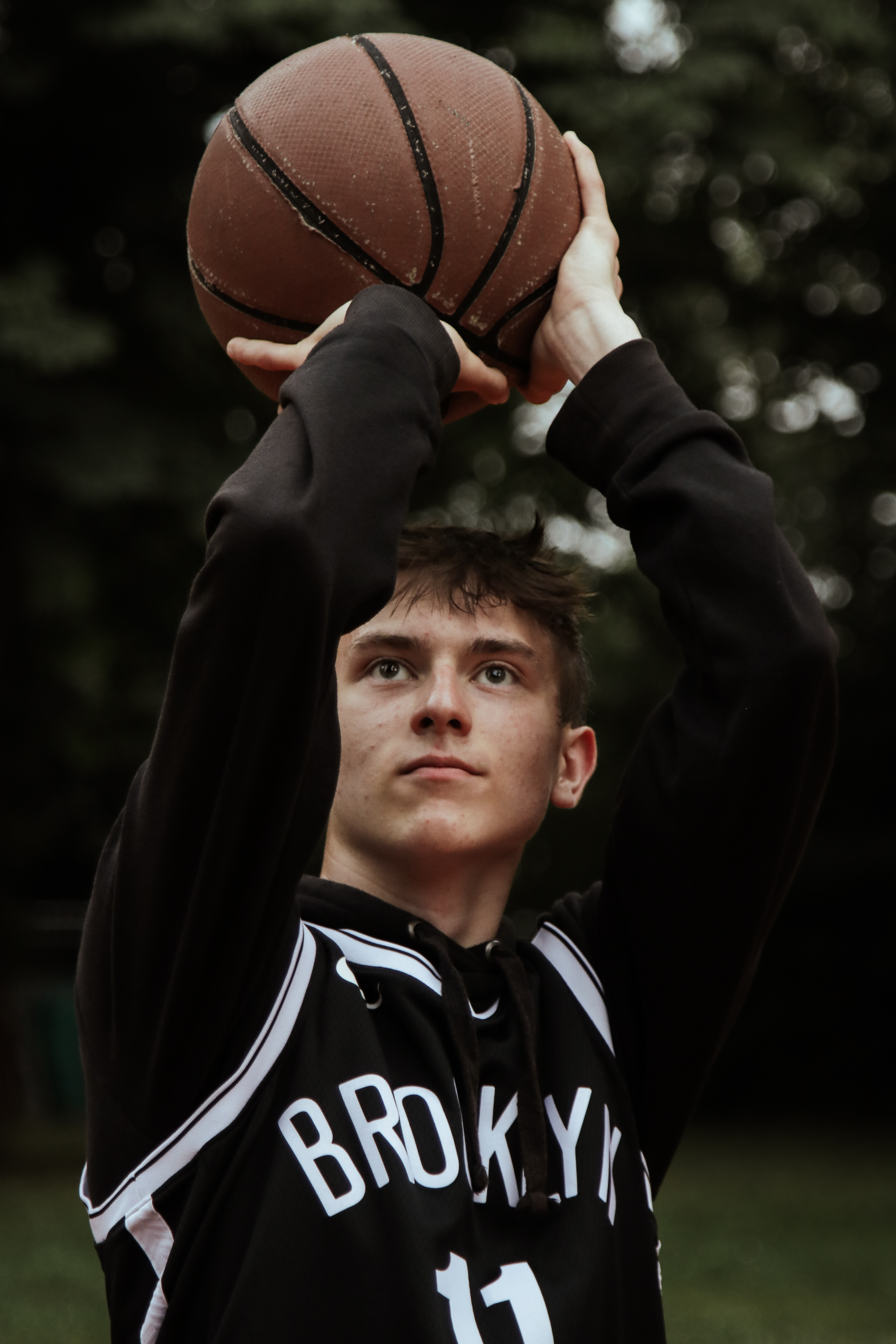 Junge mit Basketball in der Hand vorm Wurf