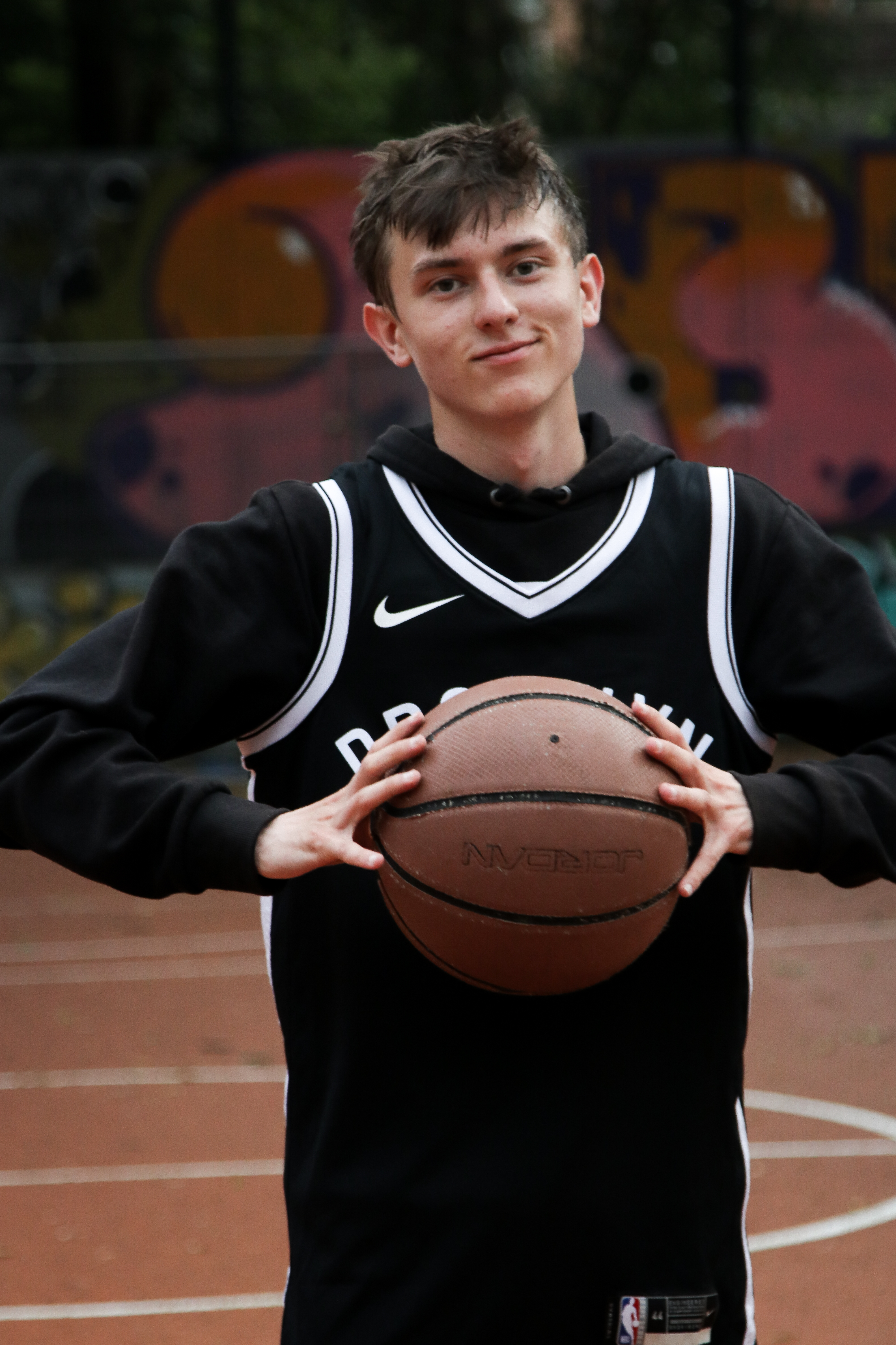 Junge mit Basketball vor der Brust